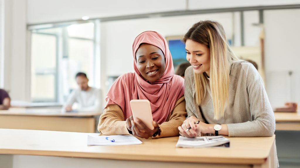 Two students looking at their phone at university
