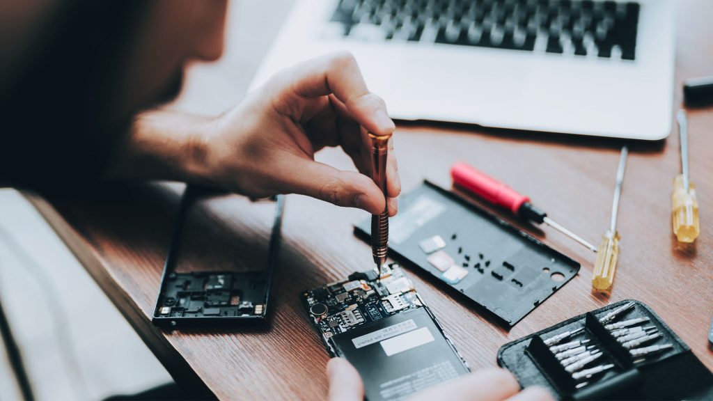 technician swapping a phones motherboard