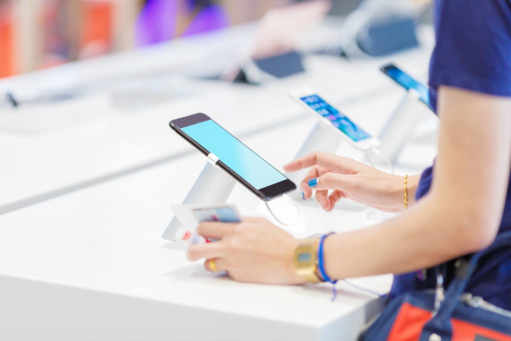 customer playing with a smartphone on display in store