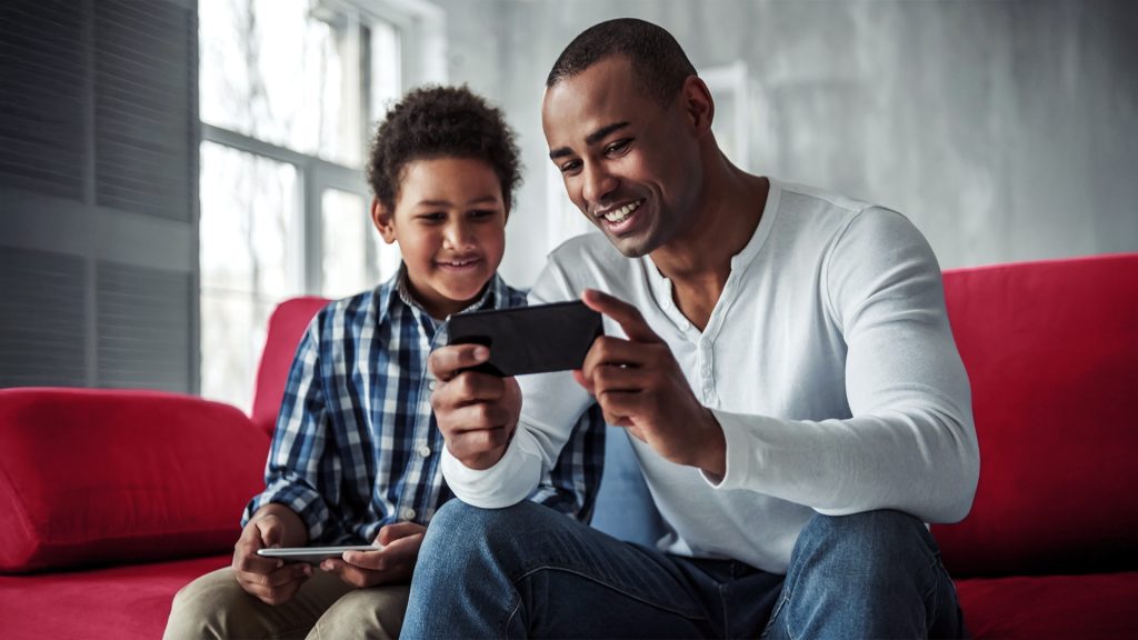 father and son watching a video on their phone